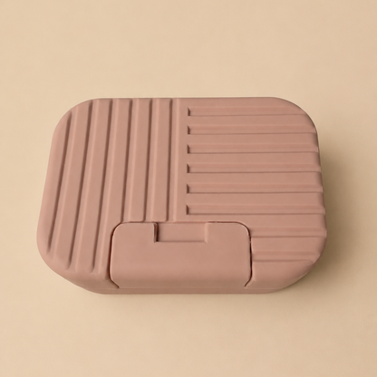 Roze reiszeepbakje gesloten op beige achtergrond