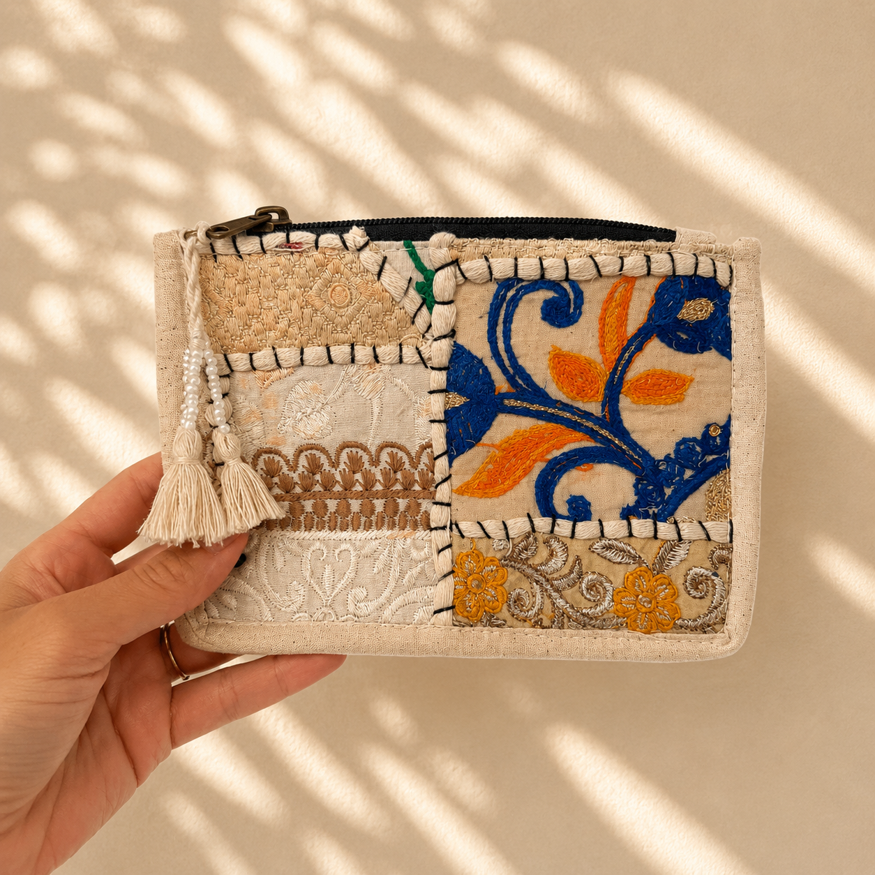 Kleine toilettas met beige patchwork, blauw en oranje borduursel, handgemaakt van 100% katoen in India. Unieke toilettas van NU-MÍ.