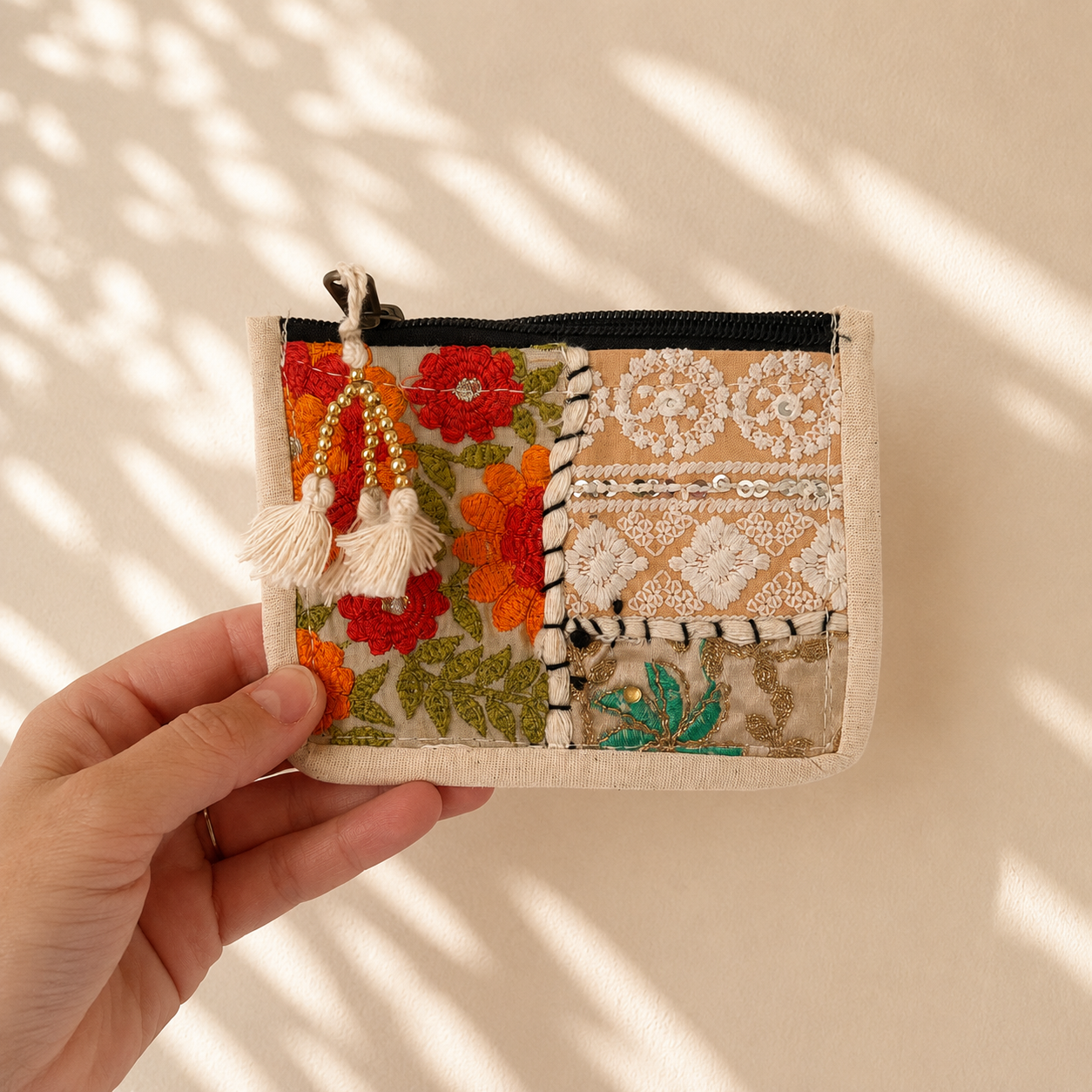 Portemonnee met beige patchwork, oranje bloemenborduursel en subtiele groene details, handgemaakt van 100% katoen in India. Kleurrijke portemonnee van NU-MÍ.