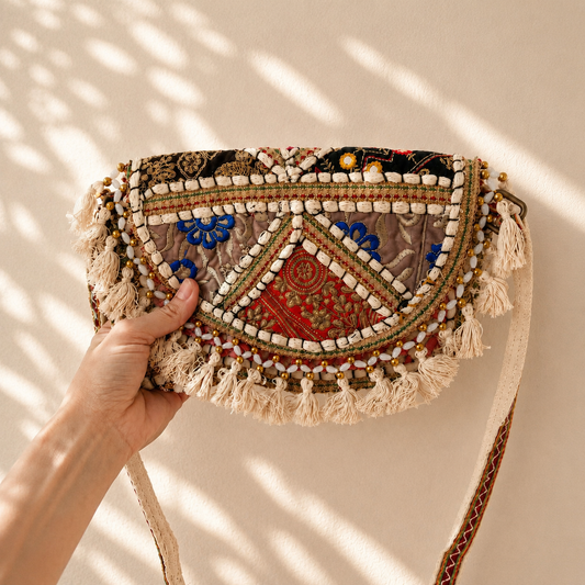 Boho crossbody tas met beige patchwork, rode en blauwe borduursels en speelse franjes, handgemaakt van 100% katoen in India. Unieke crossbody tas van NU-MÍ.