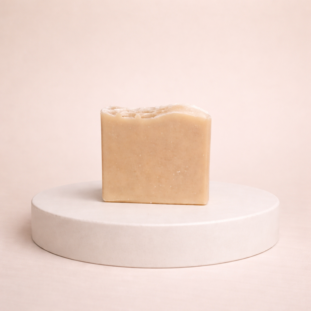 NU-MI beige reinigingszeep voor droge huid gepresenteerd op een minimalistische ronde display.