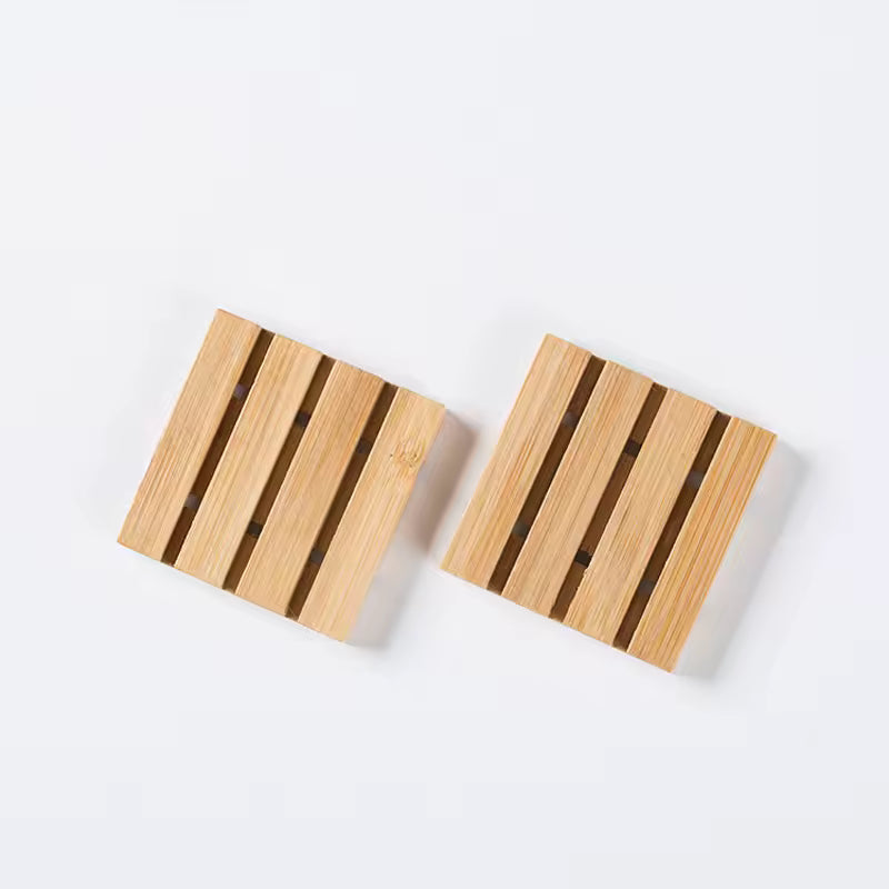 Klein houten zeepbakje met lattenstructuur, minimalistisch gepresenteerd op een lichte achtergrond.