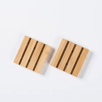 Klein houten zeepbakje met lattenstructuur, minimalistisch gepresenteerd op een lichte achtergrond.