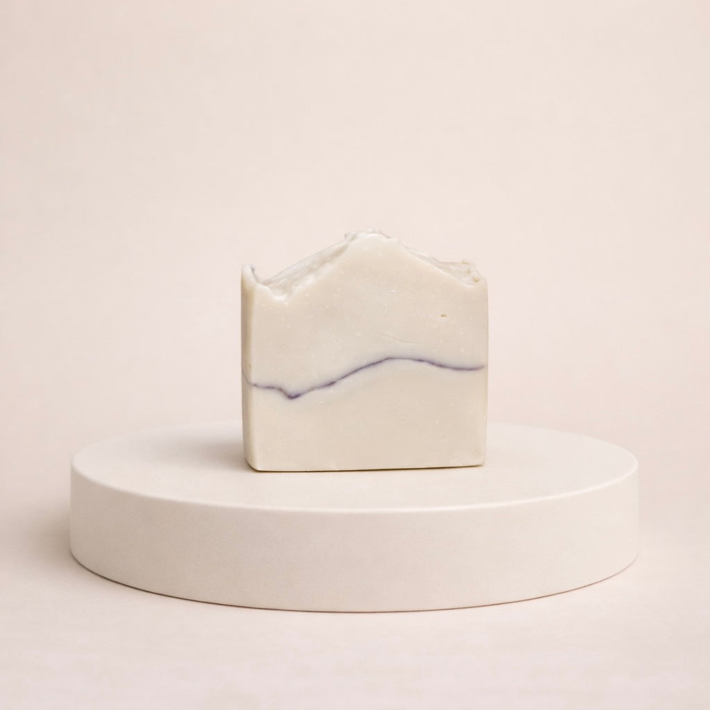 NU-MI reinigingszeep voor normale huid met subtiele paarse marmerlijn op een minimalistische ronde display.