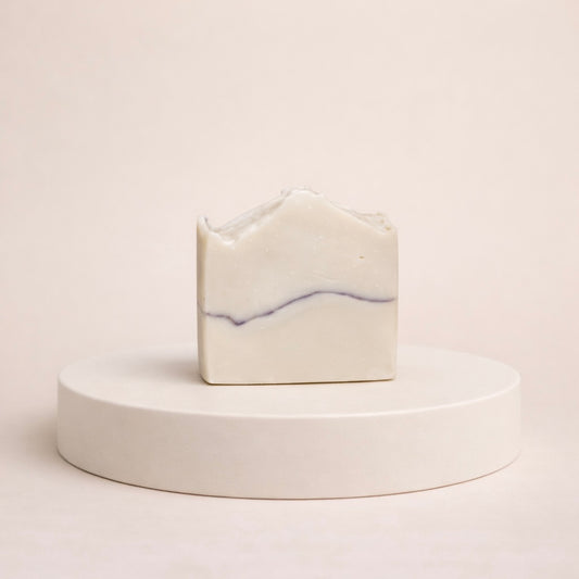 NU-MI reinigingszeep voor normale huid met subtiele paarse marmerlijn op een minimalistische ronde display.