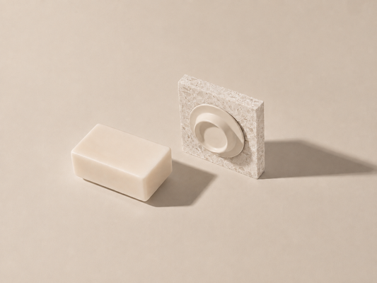 Beige Soapi magnetische zeephouder met natuurlijke zeepbar op een warme neutrale achtergrond.