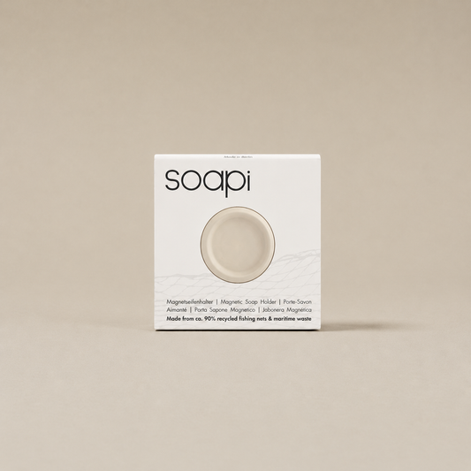 Beige Soapi magnetische zeephouder in verpakking op een rustige neutrale achtergrond.